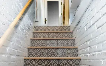 patterned stairs with white walls on side
