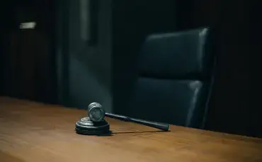 A Resting Gavel on a Table with Black Chair