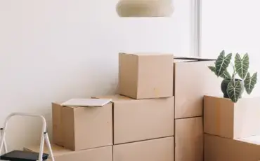 Brown cardboard boxes stacked against a white wall.