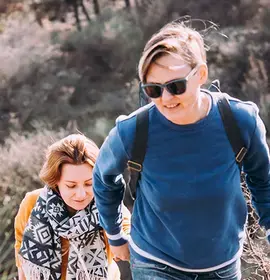 Happy lesbian couple walking on a hill